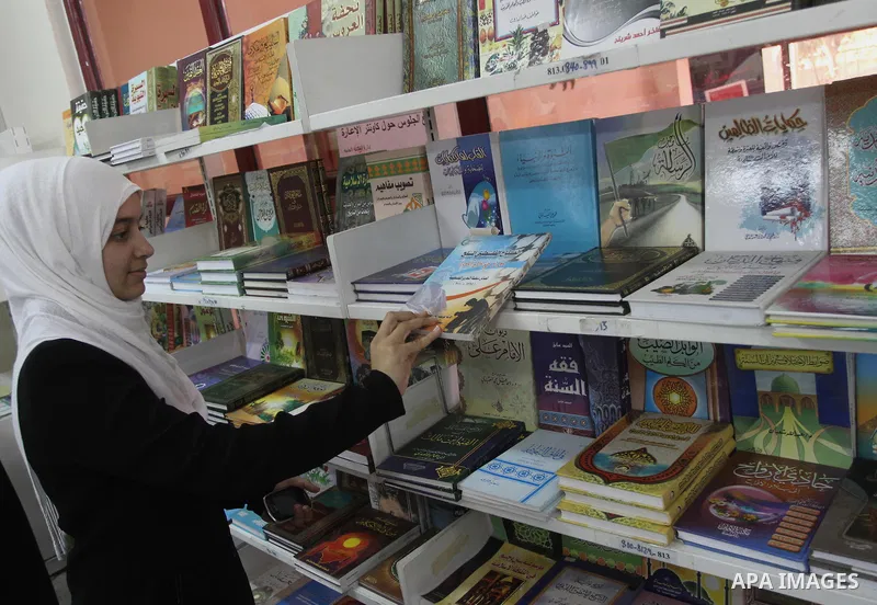 A Palestinian student reads books during the opening of an exhibition "Gaza Hashim" Book, in Gaza city , March 10, 2014. Photo by Mohammed Asad