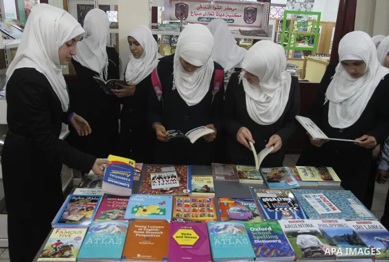 Palestinian students read books during the opening of an exhibition "Gaza Hashim" Book, in Gaza city , March 10, 2014. Photo by Mohammed Asad