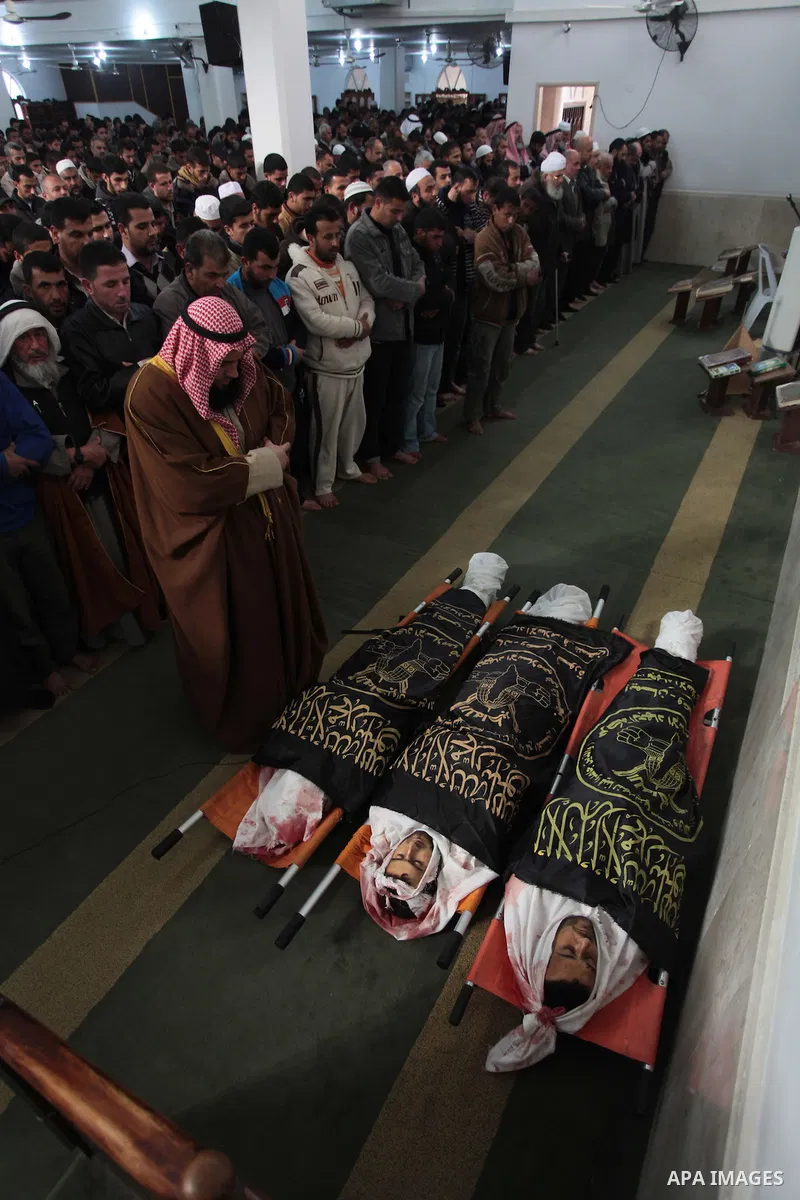 Palestinians pray next to the bodies of three Islamic Jihad militants, who were killed in an Israeli air strike, during their funeral at a mosque in Khan Younis in the southern Gaza Strip March 11, 2014. An Israeli air s...