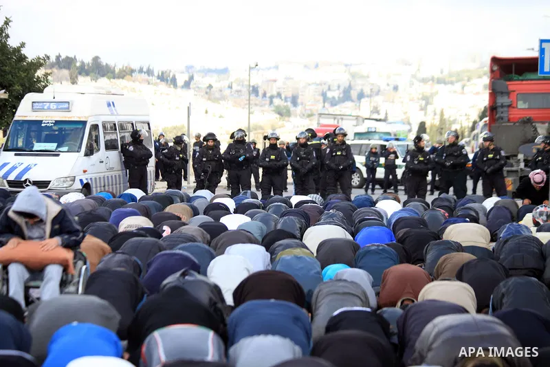 Palestinian Muslims pray outside of the Old City of Jerusalem as Israeli police block them from praying in the city's Al-Aqsa mosque, in the Ras Al-Amud neighborhood of East Jerusalem on 14 March 2014. Israel restricted...