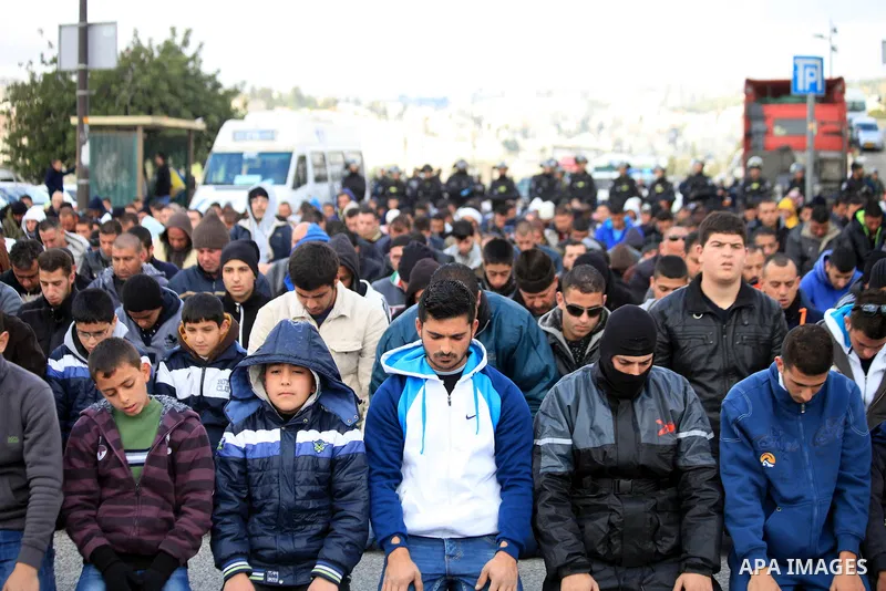 Palestinian Muslims pray outside of the Old City of Jerusalem as Israeli police block them from praying in the city's Al-Aqsa mosque, in the Ras Al-Amud neighborhood of East Jerusalem on 14 March 2014. Israel restricted...