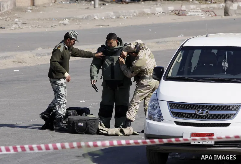 Egyptian soldiers and officials inspect the sight where gunmen killed six soldiers at a Cairo checkpoint on March 15, 2014 in an attack the military blamed on the Muslim Brotherhood movement of deposed president Mohamed...