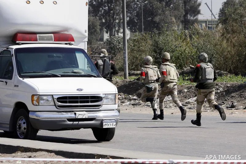 Egyptian soldiers and officials inspect the sight where gunmen killed six soldiers at a Cairo checkpoint on March 15, 2014 in an attack the military blamed on the Muslim Brotherhood movement of deposed president Mohamed...
