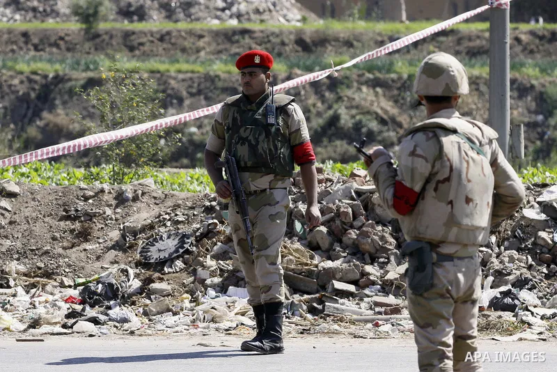 Egyptian soldiers and officials inspect the sight where gunmen killed six soldiers at a Cairo checkpoint on March 15, 2014 in an attack the military blamed on the Muslim Brotherhood movement of deposed president Mohamed...