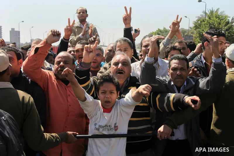 Egyptian relatives of gunmen soldiers take part a protest at the checkpoint where an attack happened in the Shubra Al-Kheima neighborhood, the outskirt of northern Cairo, Egypt, on March 15, 2014. At least six Egyptian s...