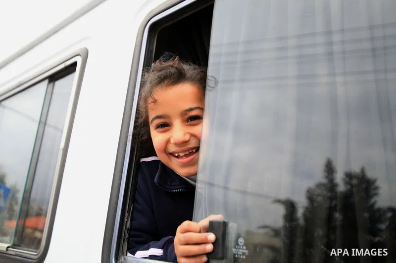 A Palestinian girl looks outside a bus window during a campaign the Spring shopping, in Jerusalem old city, on March 15, 2014. Photo by Saeed Qaq