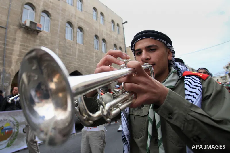 Palestinian scouts play musical instruments as they parade through the streets during a campaign the Spring shopping, in Jerusalem old city, on March 15, 2014. Photo by Saeed Qaq