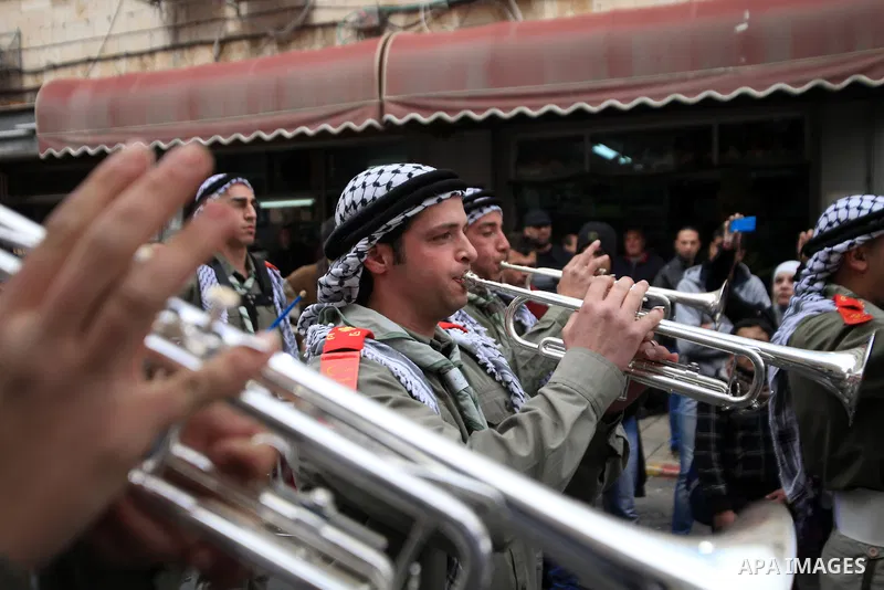 Palestinian scouts play musical instruments as they parade through the streets during a campaign the Spring shopping, in Jerusalem old city, on March 15, 2014. Photo by Saeed Qaq