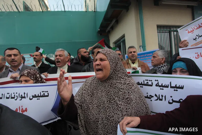 Palestinians take part in a protest against the decision made by the United Nations Relief and Works Agency (UNRWA) to reduce food aid delivered to the Gaza Strip in front of the UNRWA headquarters in Gaza City on March...