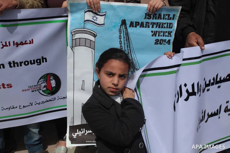Palestinian fishermen hold banners in a protest to demand the boycott of the Israeli agricultural products, during the 10th annual Israeli Apartheid Week, at the seaport of Gaza City on March 16, 2014. Photo by Ashraf Am...