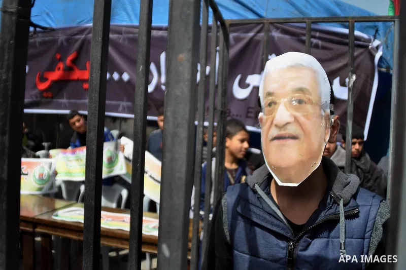 A protester wearing a mask depicting Palestinian President Mahmoud Abbas during a protest against the Egyptian-Israeli blockade on Gaza Strip, in Gaza City on March 16, 2014. Photo by Mohammed Talatene