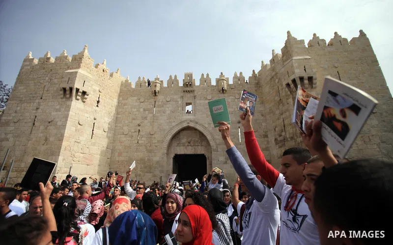 Palestinian activists participate in a reading human chain in Jerusalem's Old City, 16 March 2014. About than 7000 Palestinian activists gathered in the longest reading human chain arround the Old City walls, coincides w...