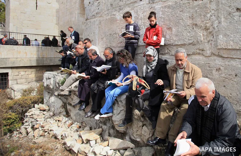 Palestinian activists participate in a reading human chain in Jerusalem's Old City, 16 March 2014. About than 7000 Palestinian activists gathered in the longest reading human chain arround the Old City walls, coincides w...