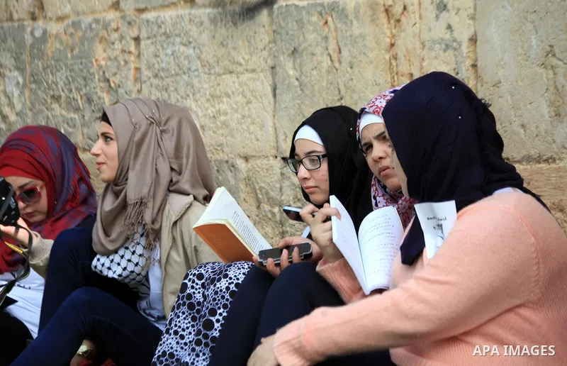 Palestinian activists participate in a reading human chain in Jerusalem's Old City, 16 March 2014. About than 7000 Palestinian activists gathered in the longest reading human chain arround the Old City walls, coincides w...
