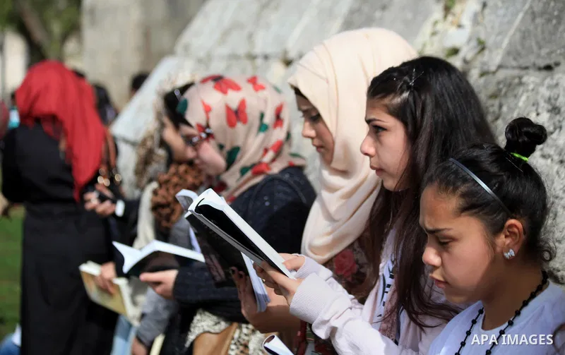 Palestinian activists participate in a reading human chain in Jerusalem's Old City, 16 March 2014. About than 7000 Palestinian activists gathered in the longest reading human chain arround the Old City walls, coincides w...