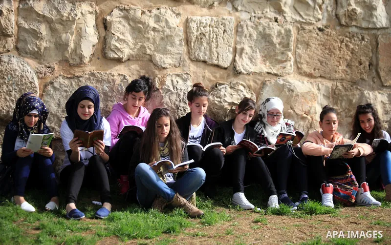 Palestinian activists participate in a reading human chain in Jerusalem's Old City, 16 March 2014. About than 7000 Palestinian activists gathered in the longest reading human chain arround the Old City walls, coincides w...