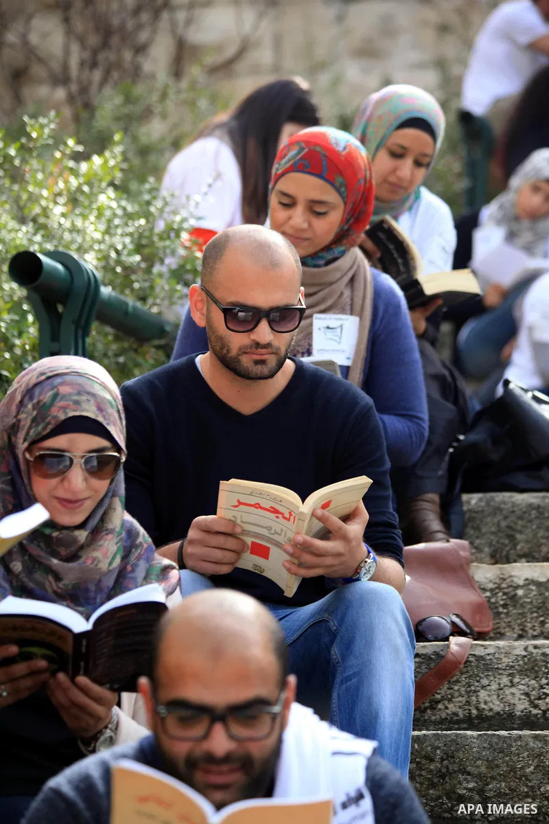 Palestinian activists participate in a reading human chain in Jerusalem's Old City, 16 March 2014. About than 7000 Palestinian activists gathered in the longest reading human chain arround the Old City walls, coincides w...