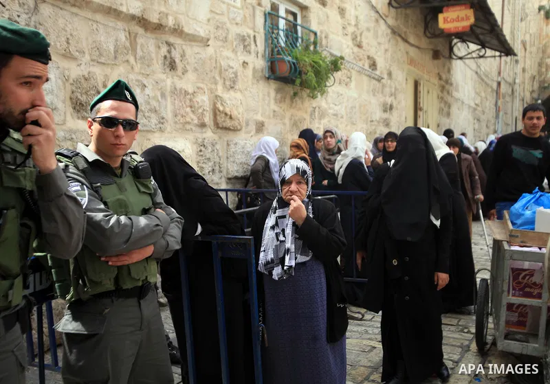 Palestinian protesters confront an Israeli policeman standing guard outside the entrance to al-Aqsa Mosque compound, Islam's third holiest site, in Jerusalem's old city on March 17, 2014, following disturbances that led...