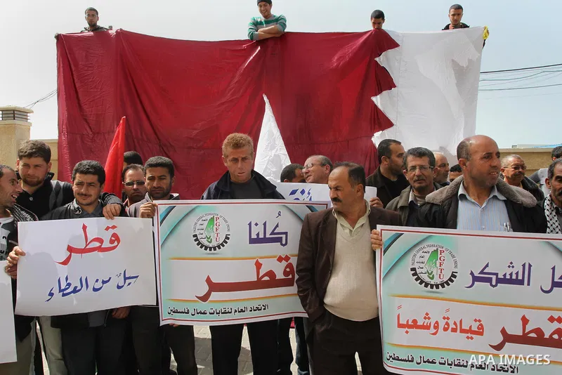 Palestinians hold placards reads in Arabic "Thanks Qatar" during a rally in Gaza city on March 19, 2014. The Emir of Qatar Sheikh Tamim bin Hamad Al Thani, spoke on Sunday with Palestinian Prime Minister in Gaza Strip, I...