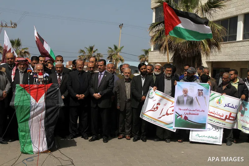 Palestinians hold pictures of Palestinian Prime Minister in Gaza Strip Ismail Haniyeh, and Emir of Qatar Sheikh Tamim bin Hamad Al Thani during a rally in Gaza city on March 19, 2014. The Emir of Qatar Sheikh Tamim bin H...