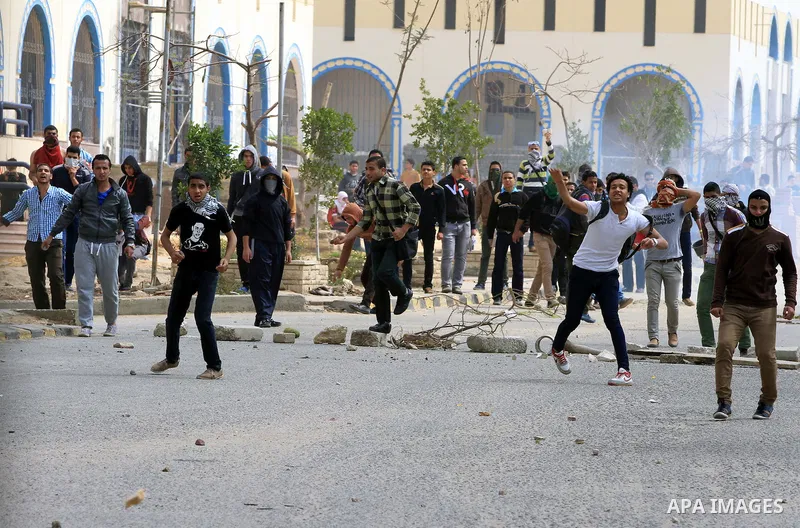 Egyptian students of al-Azhar University who are supporters of the Muslim Brotherhood and ousted Egyptian President Mohamed Mursi, throw stones at riot police during clashes in Cairo's Nasr City district, March 19, 2014....
