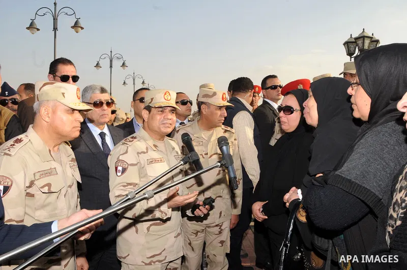 A handout picture released by the military moral affairs shows the Egypt's army chief, Field Marshal Abdel Fattah al-Sisi, speaks with relatives of the two army officers killed by a militant group, during a funeral in Ca...