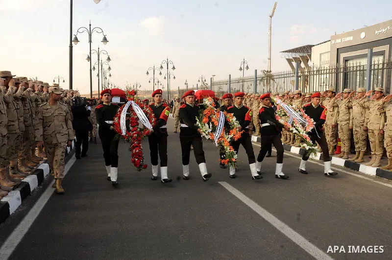 Egyptian security guards carry the bodies of two army officers killed by a militant group, during their funeral in Cairo on March 19, 2014. Two Egyptian army officers were killed on Wednesday during a raid on militant hi...