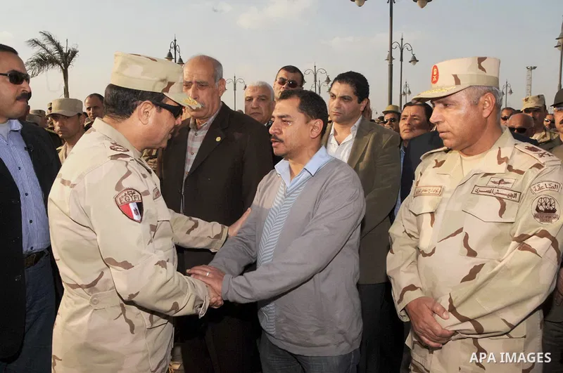 A handout picture released by the military moral affairs shows the Egypt's army chief, Field Marshal Abdel Fattah al-Sisi, speaks with relatives of the two army officers killed by a militant group, during a funeral in Ca...