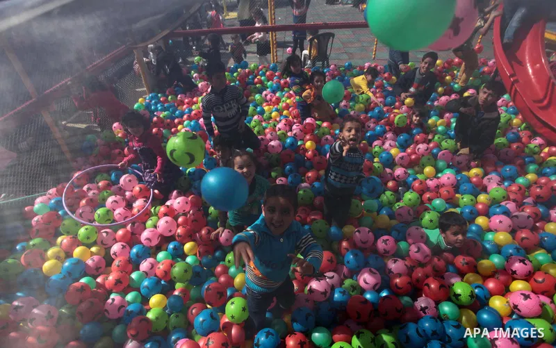 Palestinian children and their families enjoy a day at an amusement park on the eve of the Mother's Day, in Gaza City March 20, 2014. Photo by Ashraf Amra