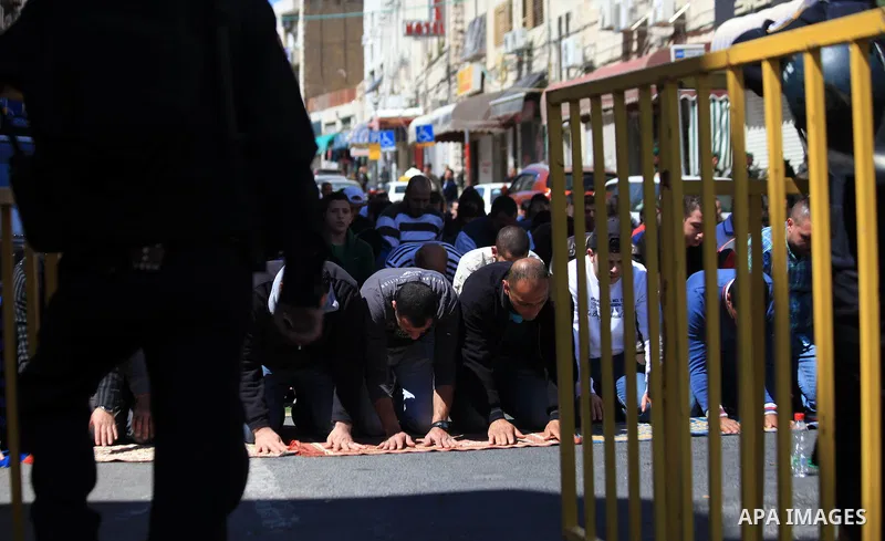 Palestinian Muslims pray outside of the Old City of Jerusalem as Israeli police block them from praying in the city's Al-Aqsa mosque, in the Ras Al-Amud neighborhood of East Jerusalem on 21 March 2014. Israel restricted...
