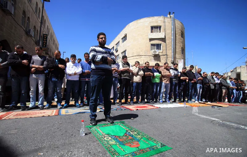 Palestinian Muslims pray outside of the Old City of Jerusalem as Israeli police block them from praying in the city's Al-Aqsa mosque, in the Ras Al-Amud neighborhood of East Jerusalem on 21 March 2014. Israel restricted...