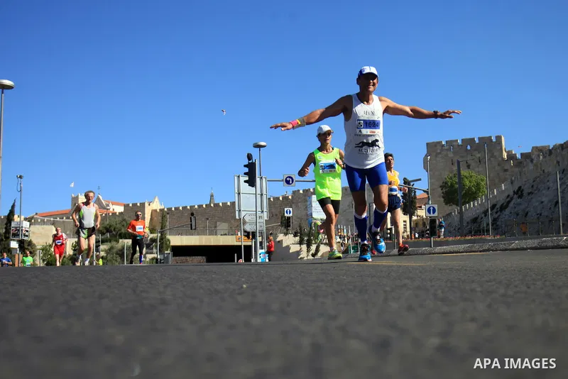 Local and international runners take part in the annual Jerusalem Marathon in the Old City on March 21, 2014. More than 15,000 runners from 50 different countries participated in the annual sporting event included runnin...