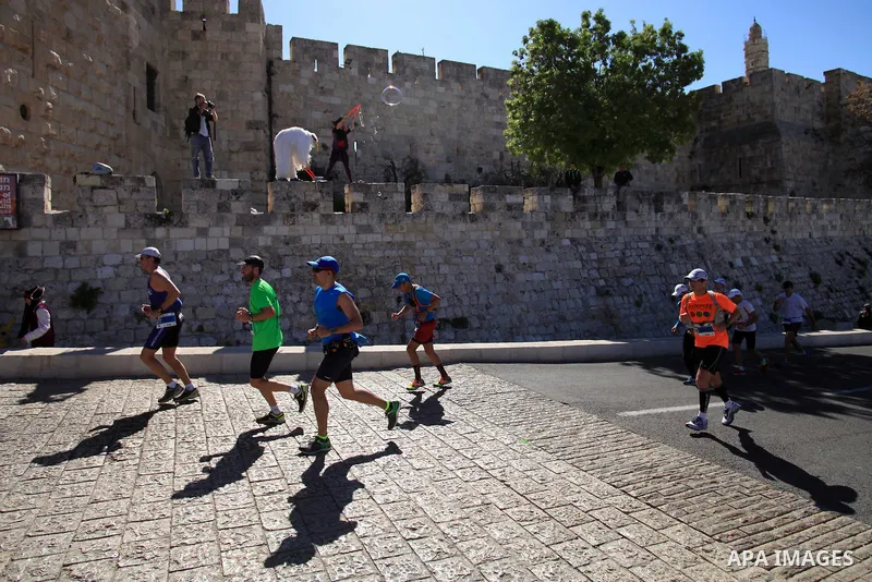 Local and international runners take part in the annual Jerusalem Marathon in the Old City on March 21, 2014. More than 15,000 runners from 50 different countries participated in the annual sporting event included runnin...