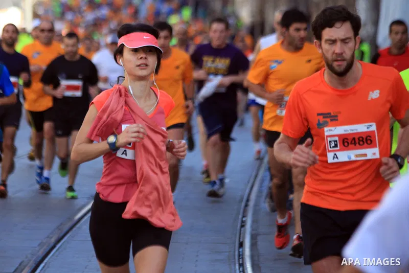 Local and international runners take part in the annual Jerusalem Marathon in the Old City on March 21, 2014. More than 15,000 runners from 50 different countries participated in the annual sporting event included runnin...