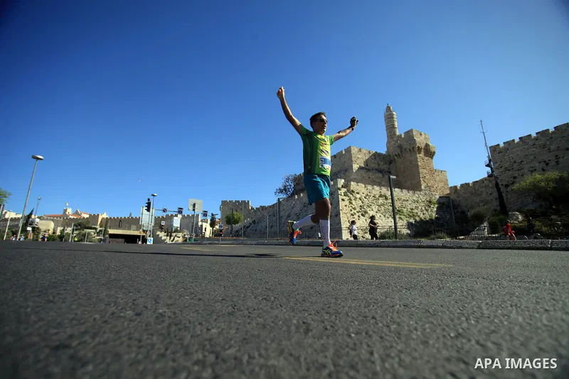 Local and international runners take part in the annual Jerusalem Marathon in the Old City on March 21, 2014. More than 15,000 runners from 50 different countries participated in the annual sporting event included runnin...