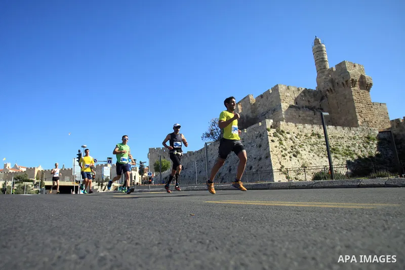 Local and international runners take part in the annual Jerusalem Marathon in the Old City on March 21, 2014. More than 15,000 runners from 50 different countries participated in the annual sporting event included runnin...