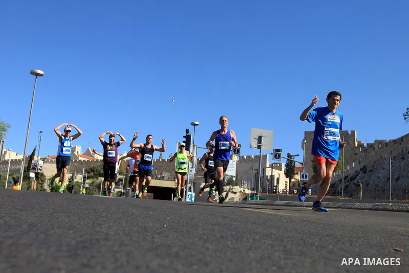 Local and international runners take part in the annual Jerusalem Marathon in the Old City on March 21, 2014. More than 15,000 runners from 50 different countries participated in the annual sporting event included runnin...