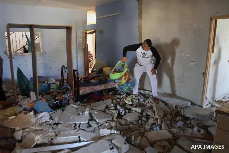 A Palestinian man checks the damage inside a house after three Palestinians were killed during Israeli operations in the West Bank refugee camp of Jenin, 22 March 2014. Three Palestinians were killed and at least nine wo...