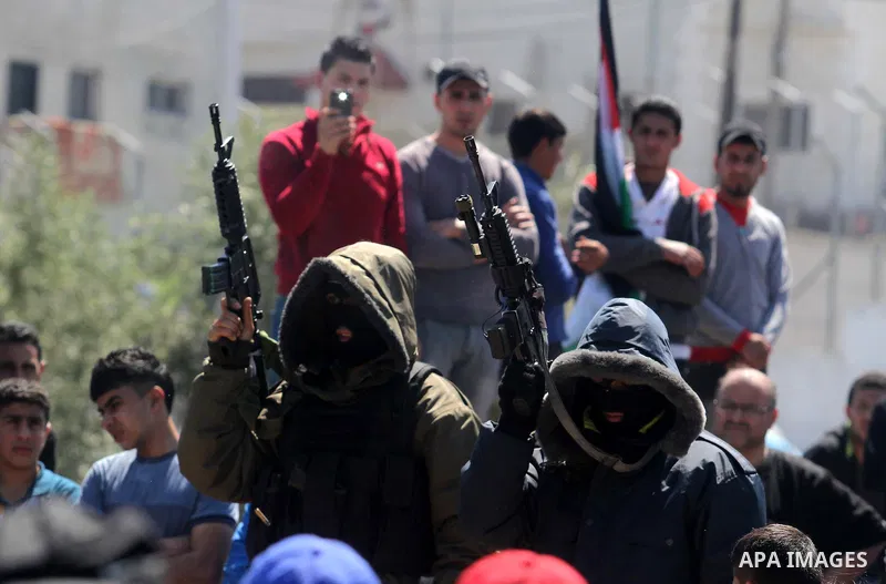 Palestinians mourn during the funeral of Hamza Abu Al-Heja, 20, a member of the military wing of Hamas, the Ezzedine al-Qassam Brigades in the northern West Bank city of Jenin on March 22, 2014 after he was killed alongs...