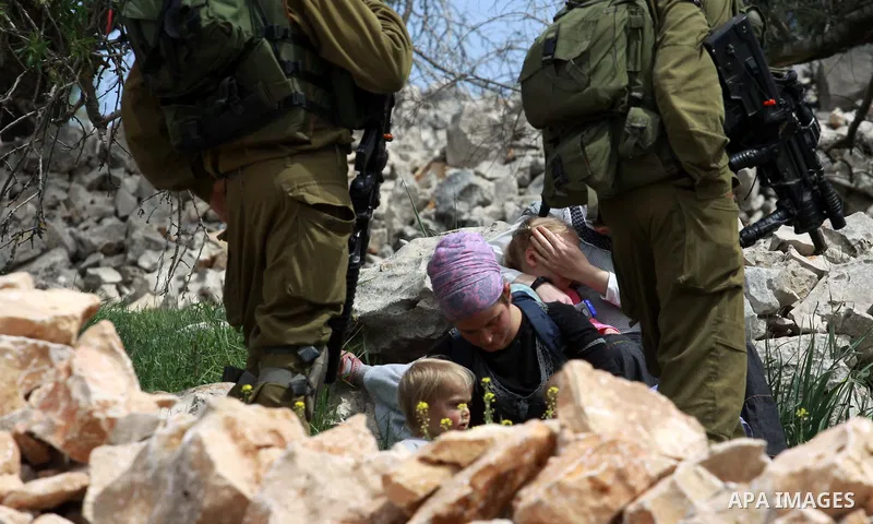 Israeli security forces stand guard in front of Jewish settlers in the West Bank village of Burin south of Nablus, March 23, 2014. Clashes broke out Sunday morning after Jewish settlers from the nearby Bracha settlement...