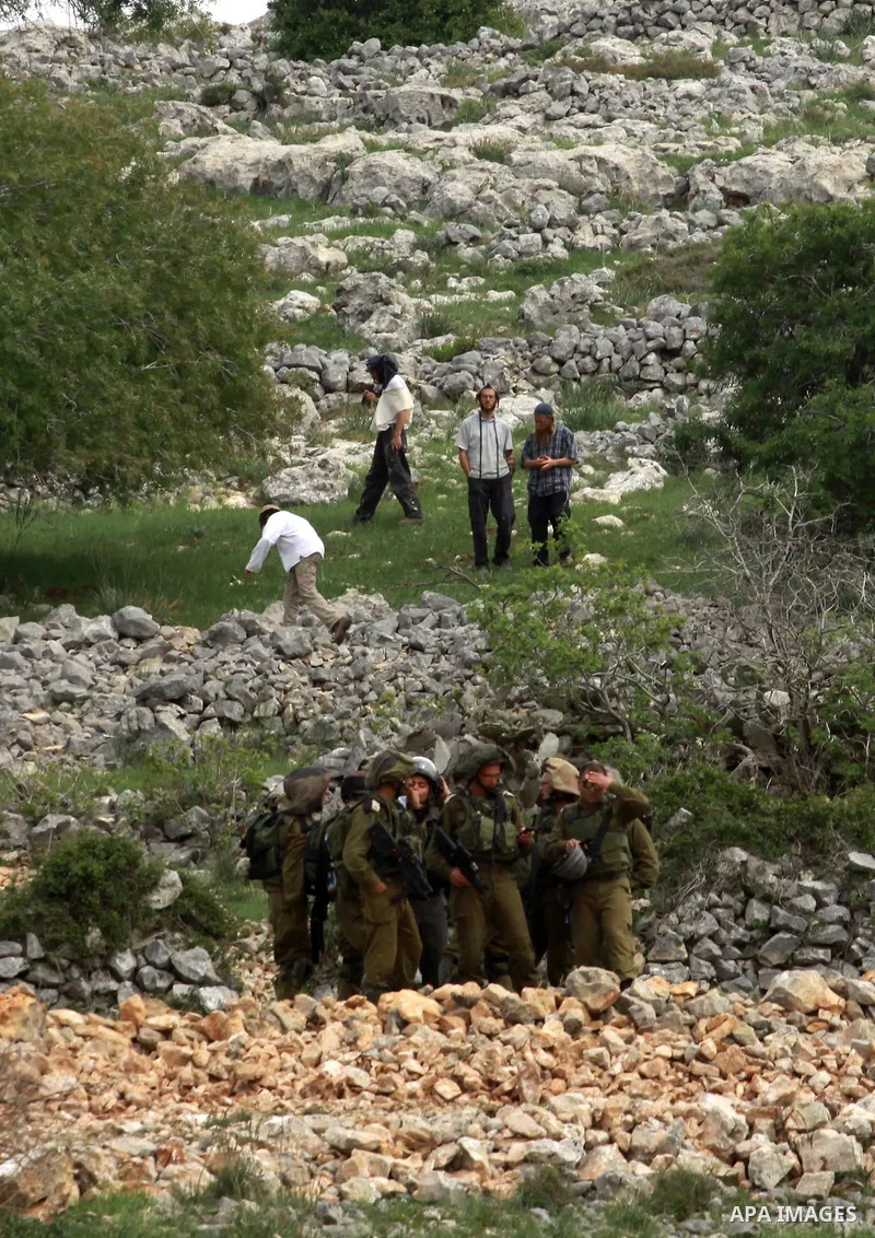 Israeli security forces stand guard in front of Jewish settlers in the West Bank village of Burin south of Nablus, March 23, 2014. Clashes broke out Sunday morning after Jewish settlers from the nearby Bracha settlement...