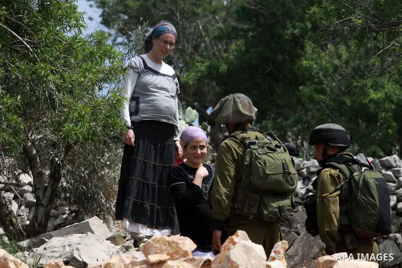 Israeli security forces stand guard in front of Jewish settlers in the West Bank village of Burin south of Nablus, March 23, 2014. Clashes broke out Sunday morning after Jewish settlers from the nearby Bracha settlement...