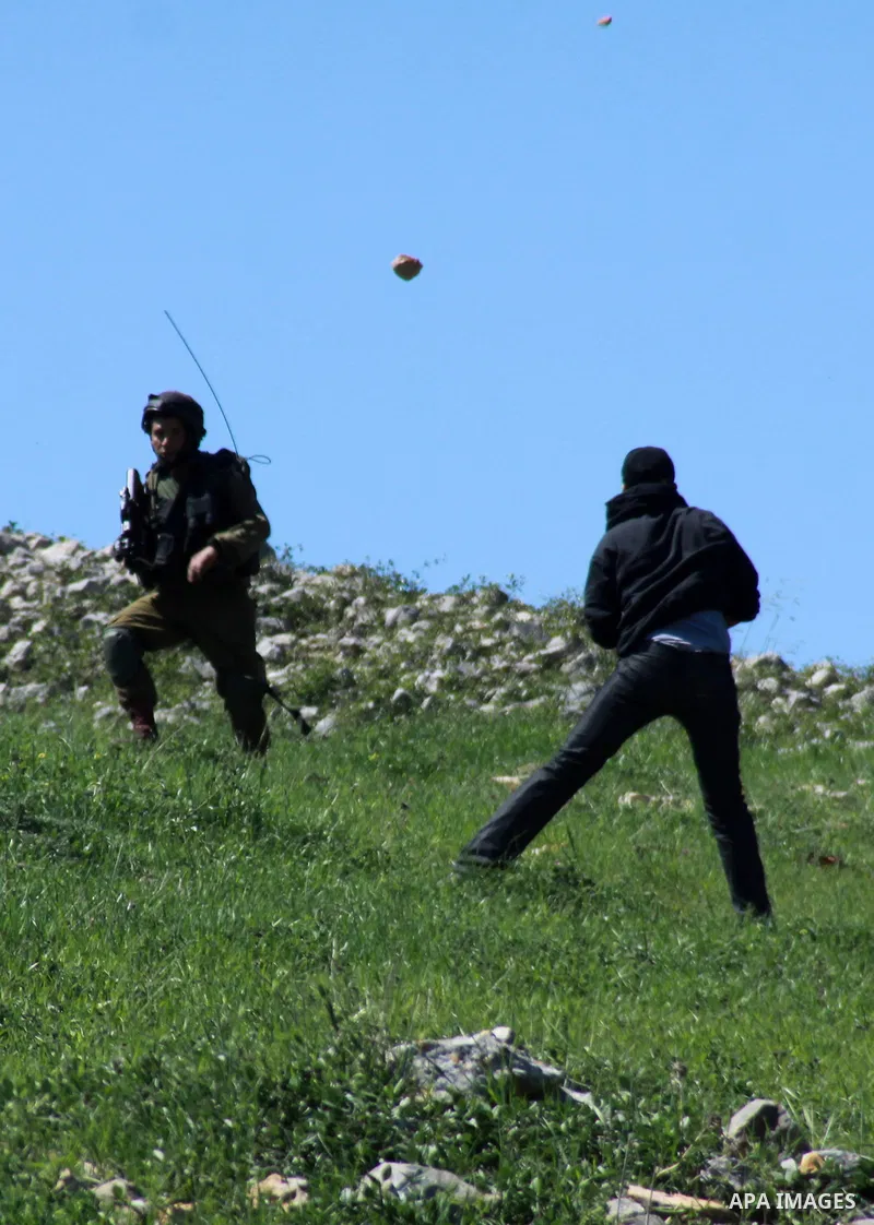A Palestinian protester throws stones at Israeli security forces during clashes in the West Bank village of Burin on March 28, 2014. Israel has told the Palestinians it will not free the final batch of prisoners they had...