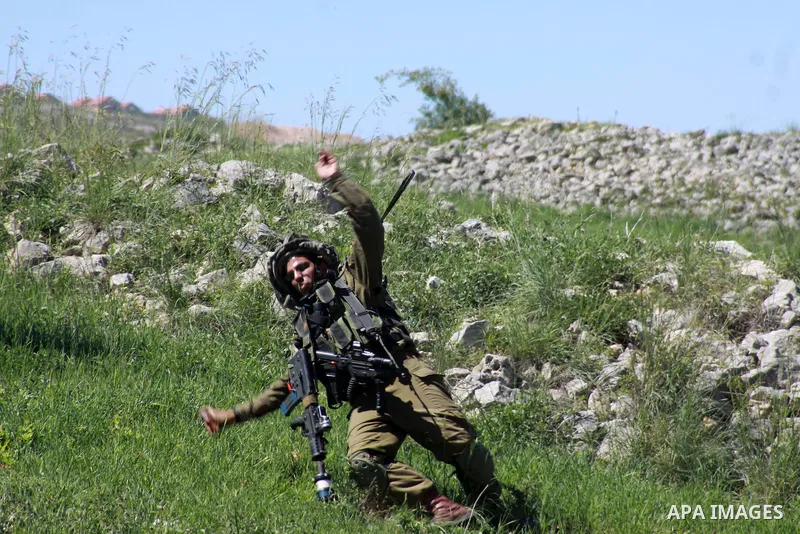 A member of Israeli security forces falls on the ground as he runs after Palestinian protesters during clashes in the West Bank village of Burin on March 28, 2014. Israel has told the Palestinians it will not free the fi...
