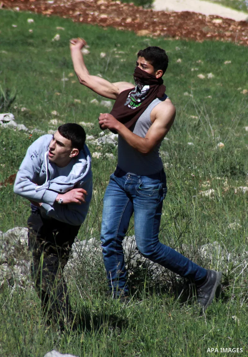 Palestinian protesters throw stones at Israeli security forces during clashes in the West Bank village of Burin on March 28, 2014. Israel has told the Palestinians it will not free the final batch of prisoners they had b...