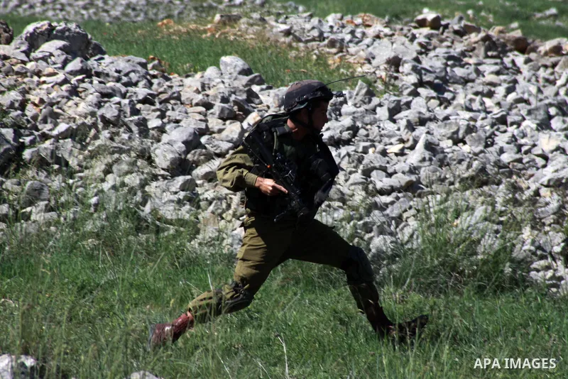 A member of Israeli security forces runs after Palestinian protesters during clashes in the West Bank village of Burin on March 28, 2014. Israel has told the Palestinians it will not free the final batch of prisoners the...