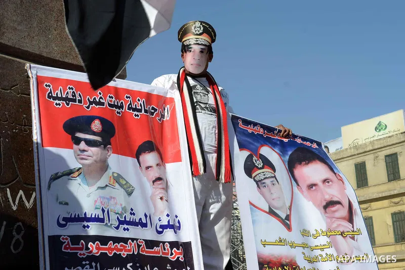 Egyptian supporter of Former Egyptian military chief and presidential candidate Abdel-Fattah el-Sisi, hold his pictures during a rally to support him in Cairo on March 28, 2014. Al-Sisi announced on Wednesday his preside...