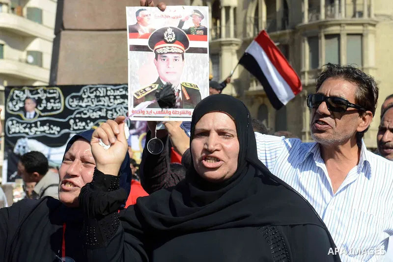 Egyptian supporter of Former Egyptian military chief and presidential candidate Abdel-Fattah el-Sisi, hold his pictures during a rally to support him in Cairo on March 28, 2014. Al-Sisi announced on Wednesday his preside...