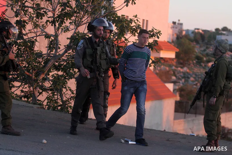 Israeli security forces detain a Palestinian youth during clashes with Israeli security forces in the West Bank village of Silwad, north of Ramallah, on March 28, 2014 following a protest of Palestinians against the expa...