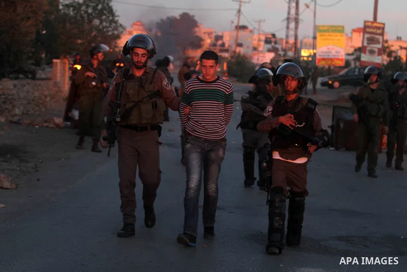 Israeli security forces detain a Palestinian youth during clashes with Israeli security forces in the West Bank village of Silwad, north of Ramallah, on March 28, 2014 following a protest of Palestinians against the expa...